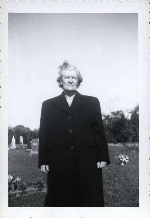 Photograph, woman standing in cemetery